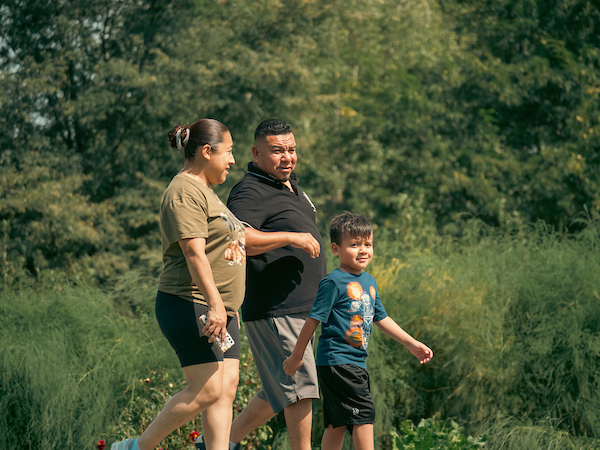 A family of three walking in a park