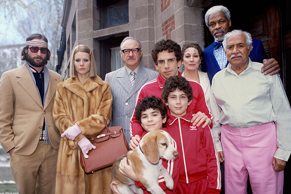 Publicity still from the film The Royal Tenenbaums, depicting the Tenenbaum family posing together in front of their brownstone.